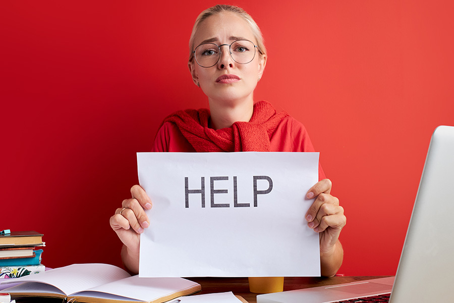 Confused teacher holds up sign saying help